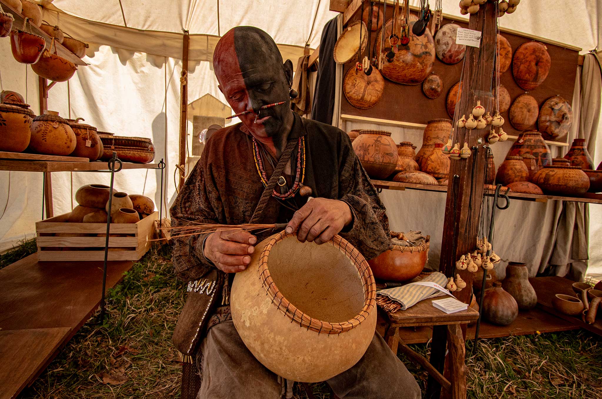 Crafter in Native American garb working on a pot