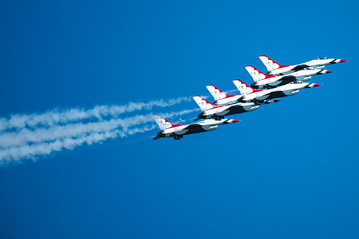 Close up of jets in formation in tight group, smoke trails following