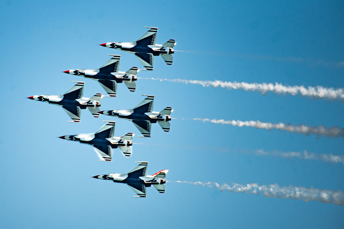 bottom view of five jets in formation, forming a triangle