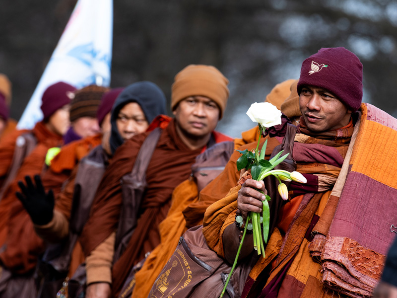 Monk with flowers thanking an onlooker